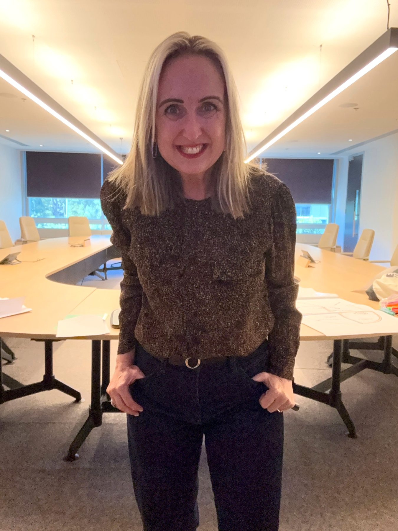 Gabby Horak in a leopard print top, leading a discussion in a boardroom